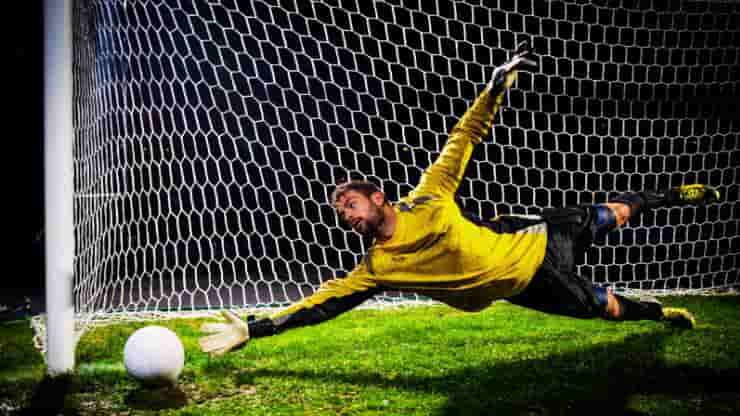 action bias in sports - a soccer goaltender jumps for the ball